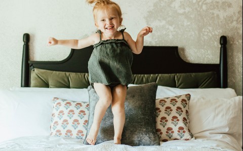 a girl jumping in a bed