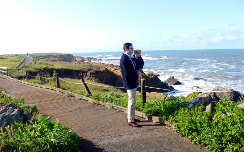 father and child looking at ocean