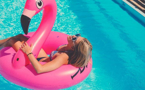 Woman floating on inflatable flamingo