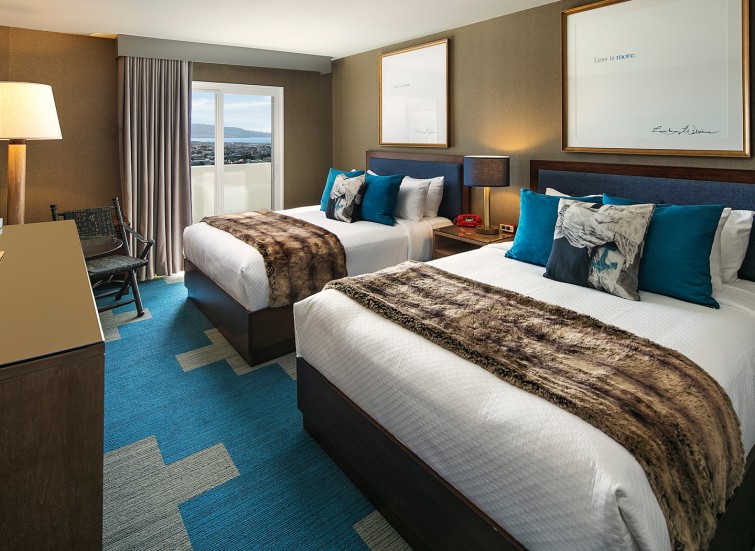hotel room with 2 beds and blue and light brown decorations