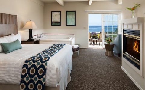 a guest room with a jacuzzi and views of the ocean