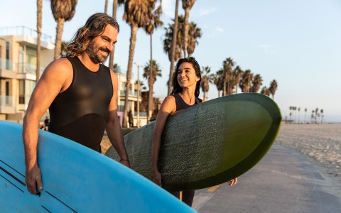 couple walking with surf boards