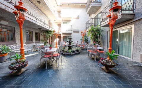 hotel patio with round tables and orange chairs