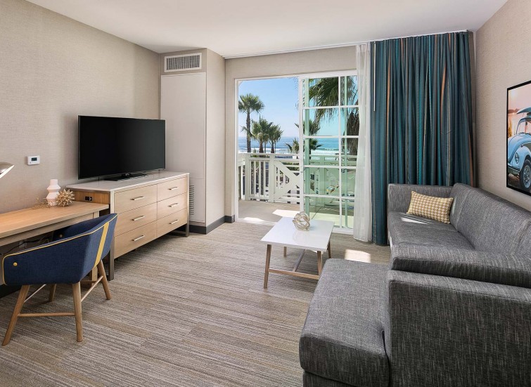 a guest suite with a sitting area and view of beach
