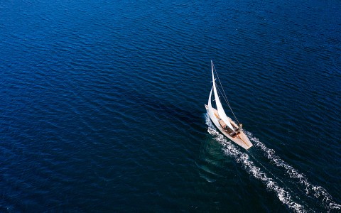 Overhead view of a sailboat in the middle of the ocean