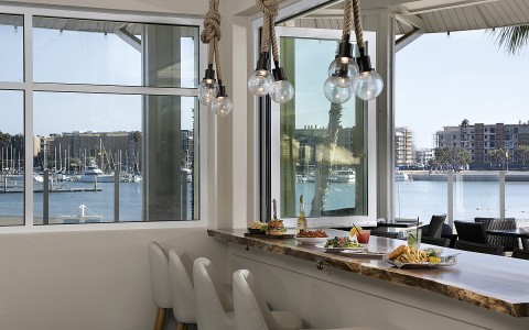 bar to table with plates of food facing the ocean