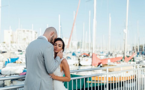 Bride and groom embracing with a view of the marina