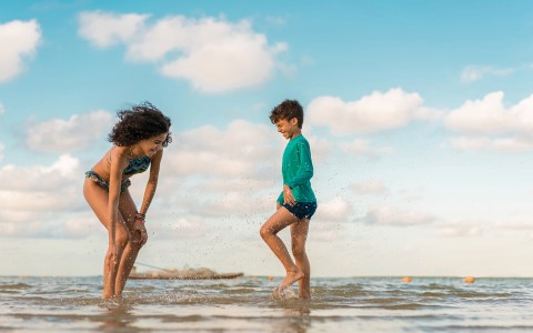 Boy and a girl playing in ankle deep shoreline