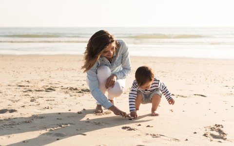 Woman playing with a small child on the beach