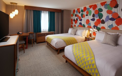 Hotel room with 2 beds and a colorful back wall
