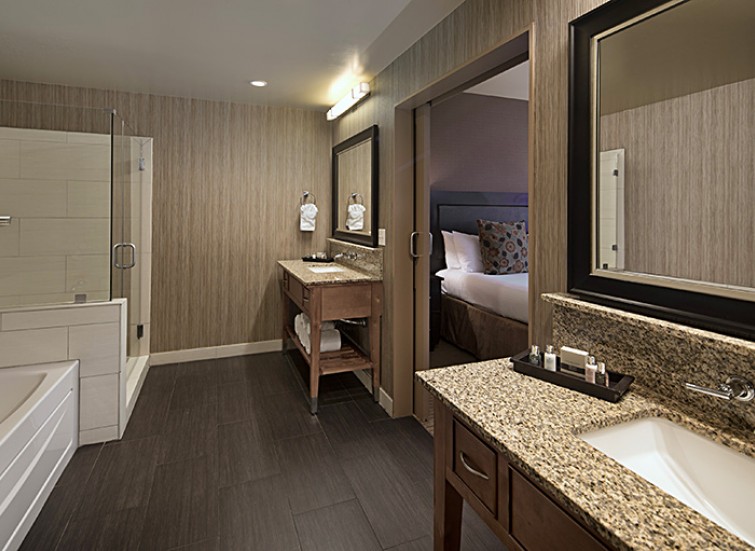 hotel room with bathroom with 2 separate vanities
