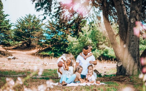 couple with five children having a picnic wearing all white