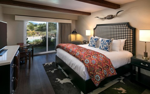 Hotel bedroom with ranch inspired decor and a view of pool