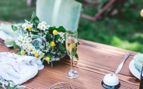 detailed yellow and green wedding decor next to champagne flute