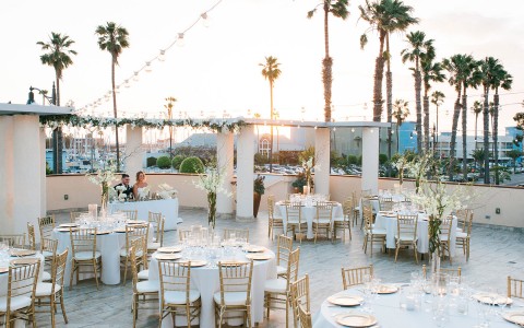rooftop wedding venue with golden chairs and light tablecloths