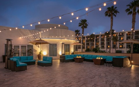 rooftop lounge area with comfy teal sectionals and twinkly lights