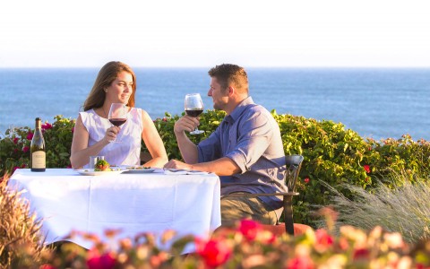 couple drinking wine in front of ocean