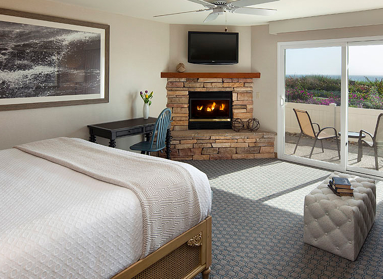 hotel room with fireplace and view of ocean
