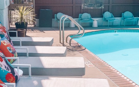 pool chairs next to crystal blue pool