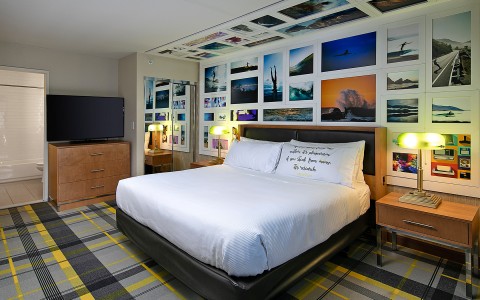 king bed with posters of water sports covering the wall