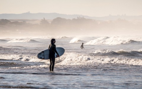 a woman surfing in pismo beach