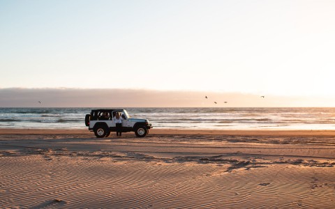 a jeep driving along the beach
