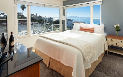 a bedroom with windows and views of the ocean