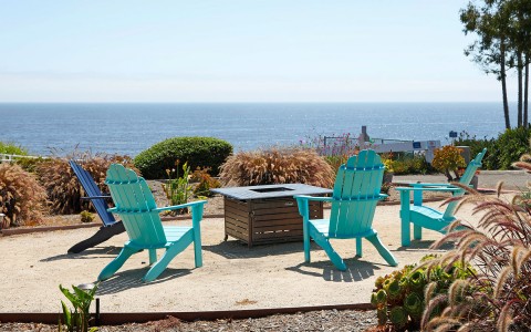 chairs and a fire pit by the ocean