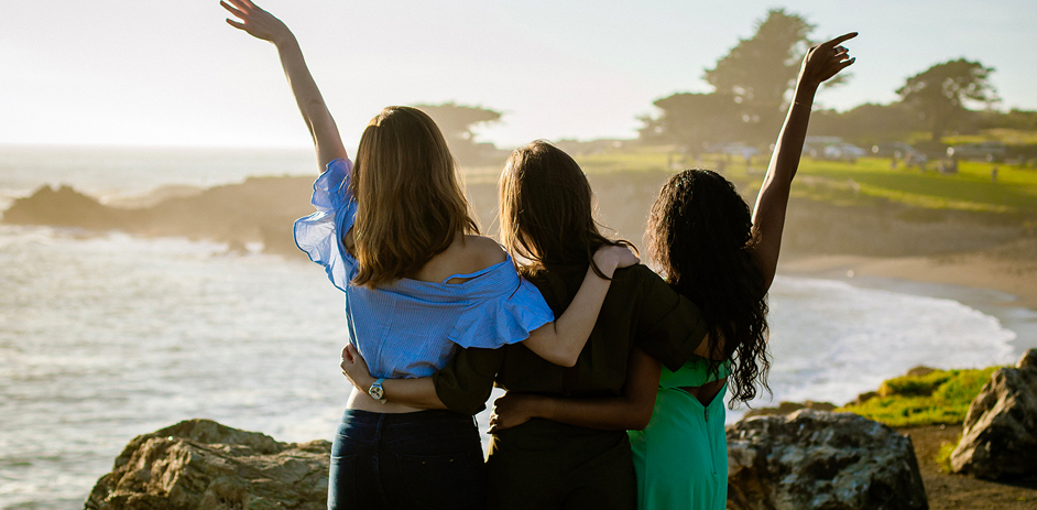 friends posing in front of ocean