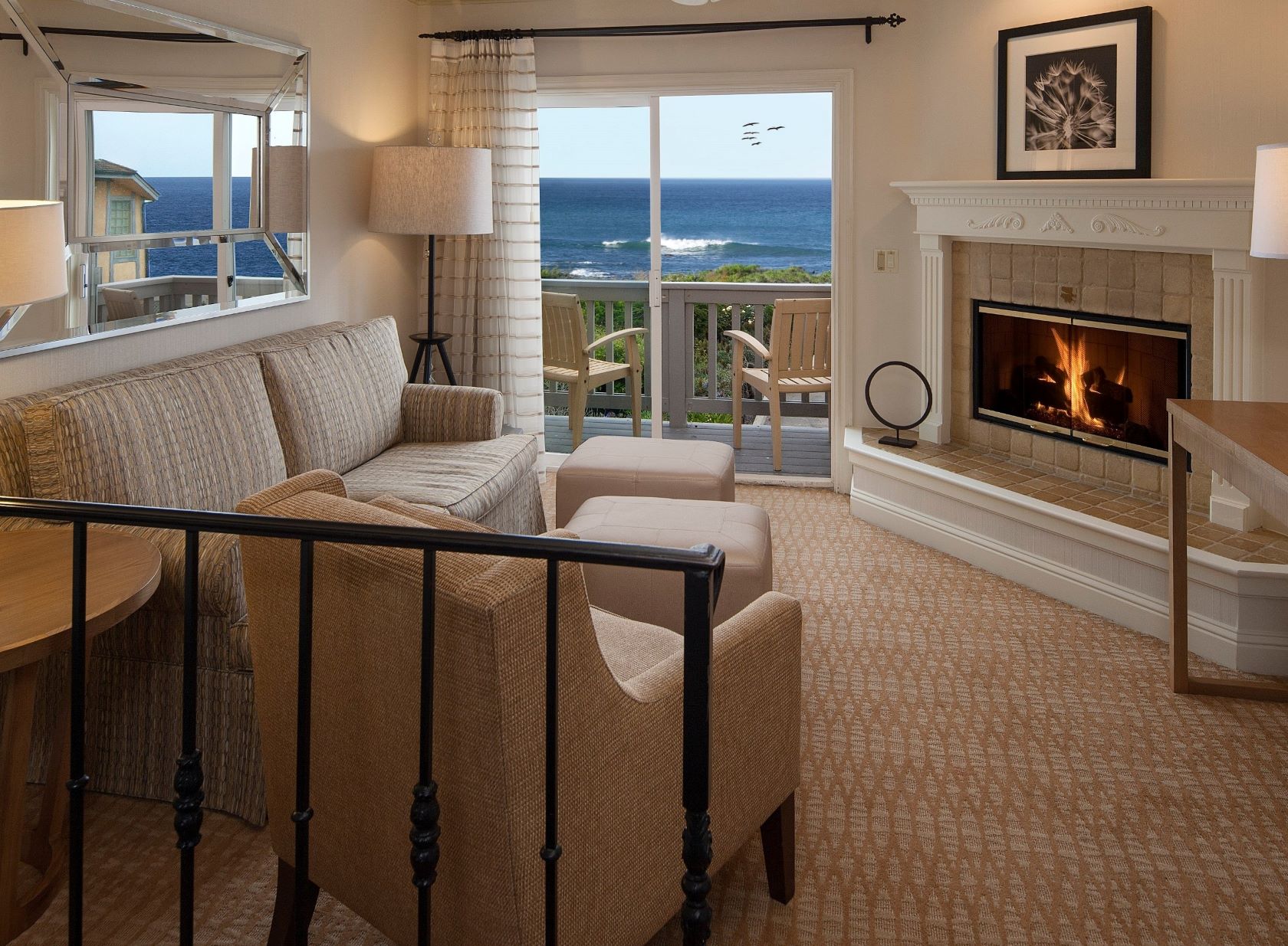 hotel suite living area with ocean view and fireplace