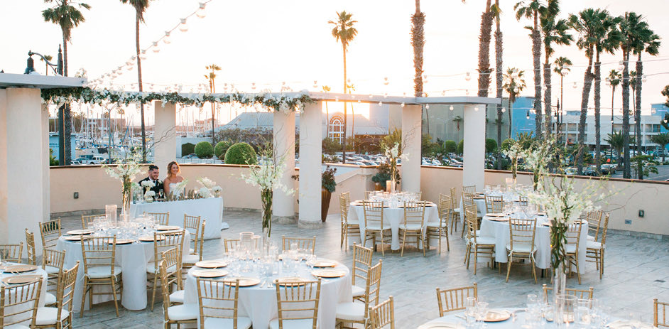 rooftop wedding venue with beautiful light desks and tablecloths as the sun sets