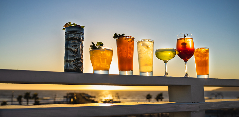 seven alcoholic summer cocktails on display overlooking ocean views