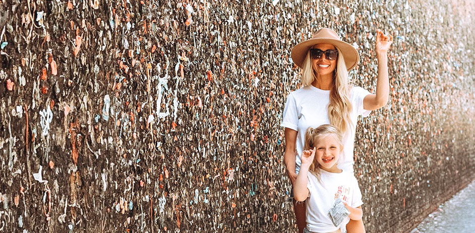 lady in a hat in front of a bubblegum wall