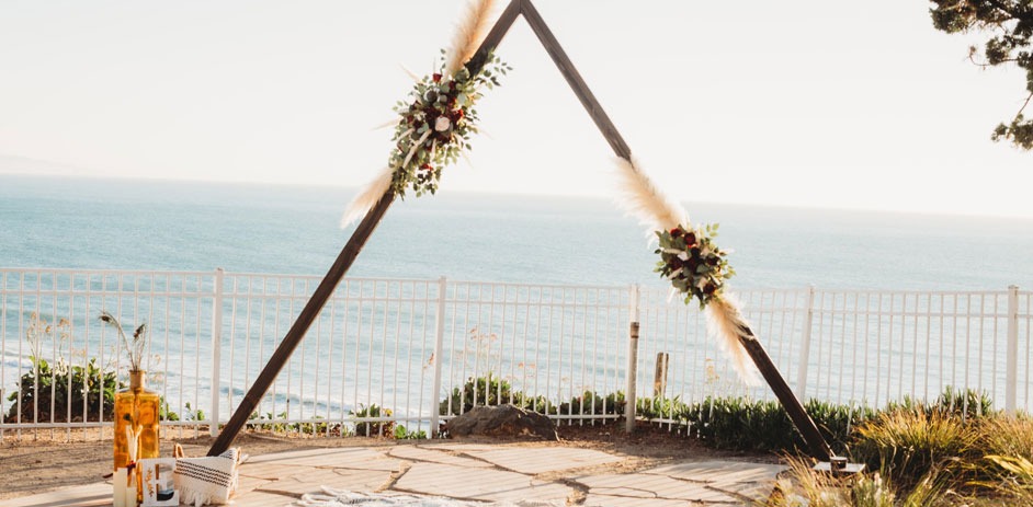 wedding triangular arch with an ocean view background 