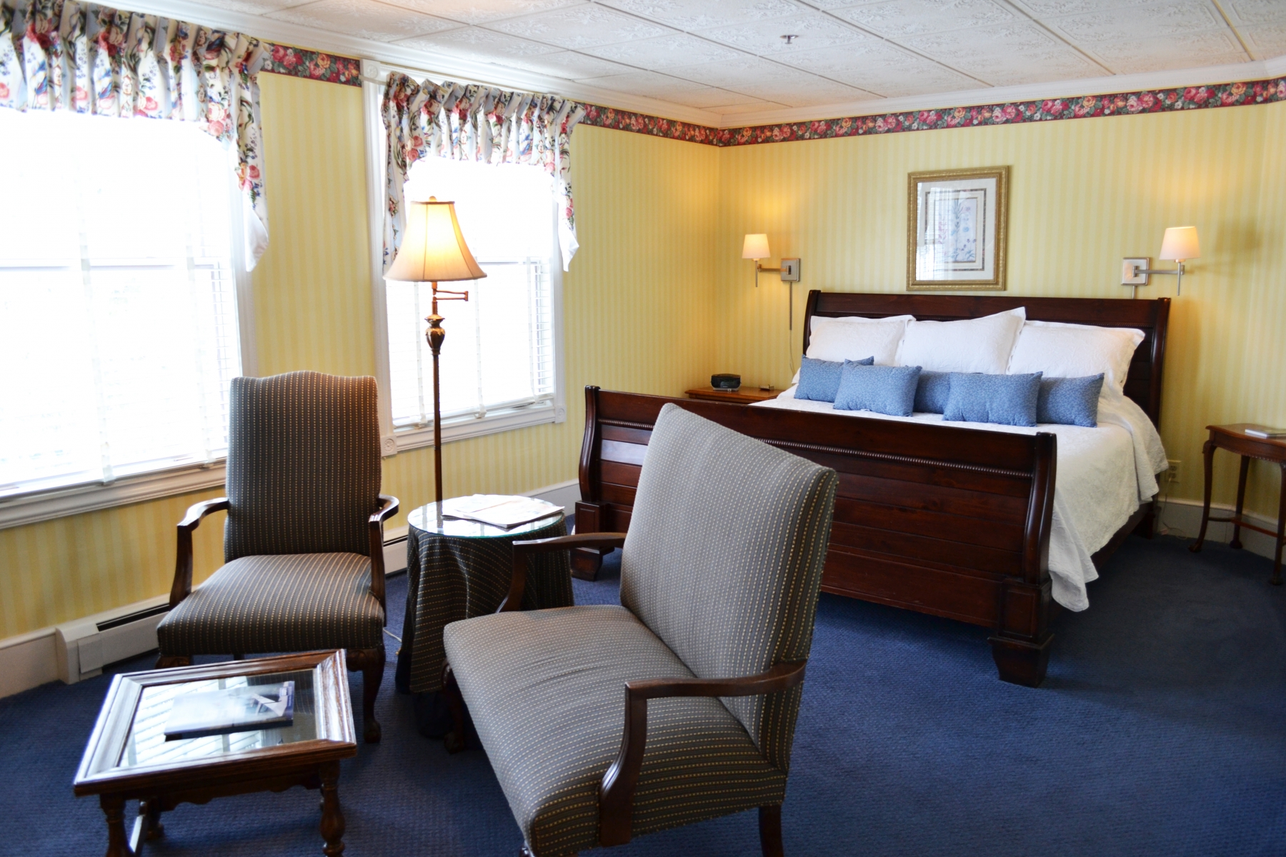 large hotel room with king bed and two chairs with seating area 