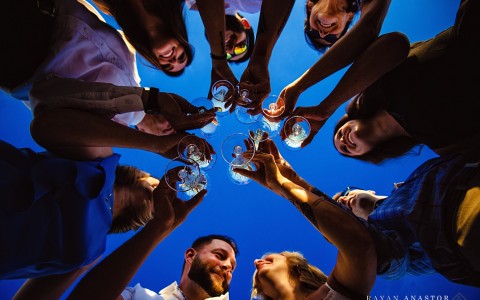 group of people holding their wine glass in a circle 