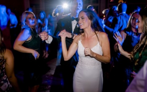 bride and groom dancing in the ballroom with blue light 