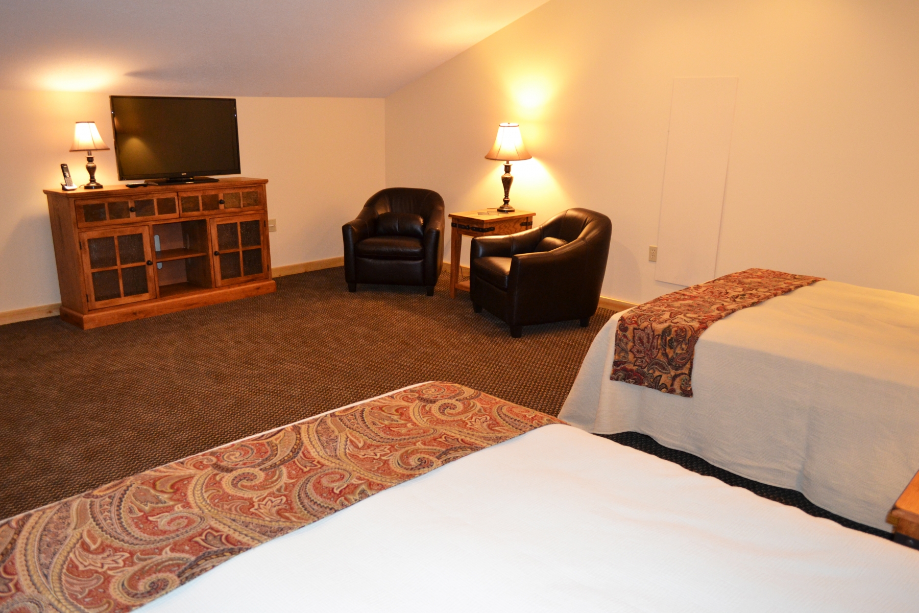 hotel bedroom with two beds a seating area and tv stand