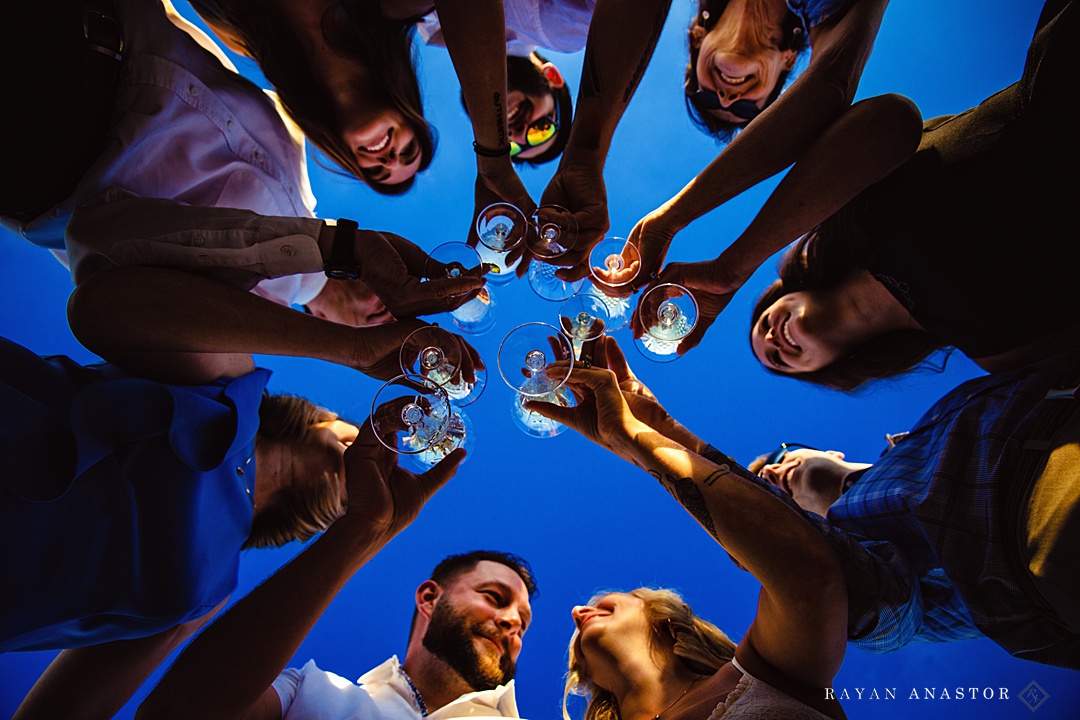 group of people holding their wine glass in a circle 