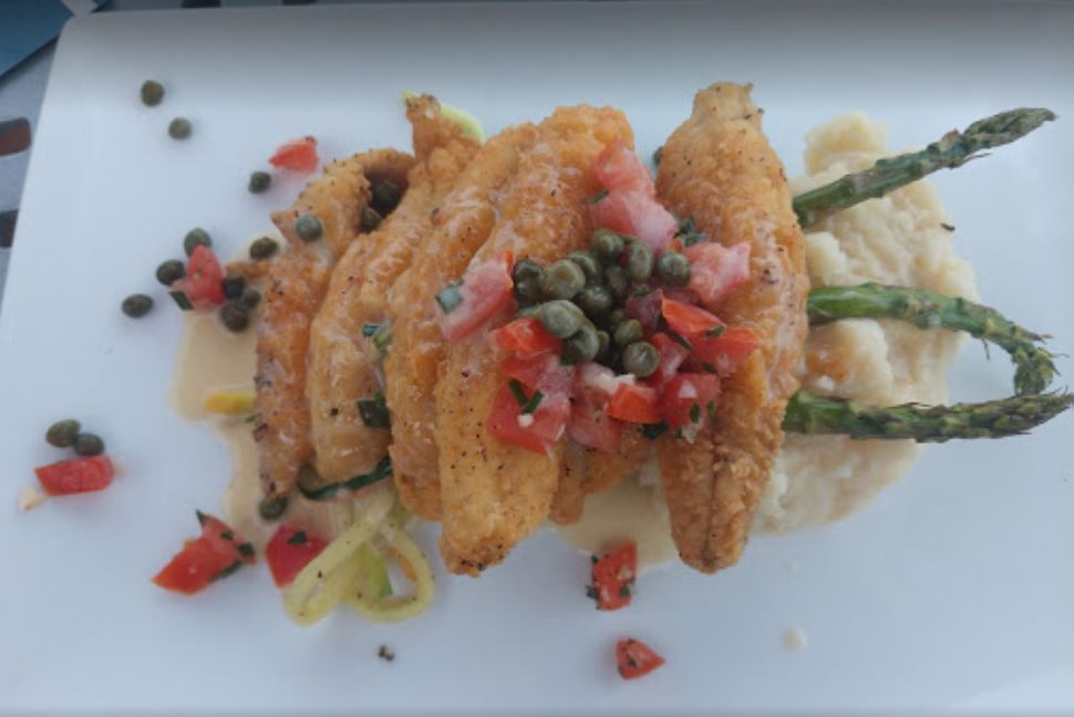 fried food with capers on a white plate