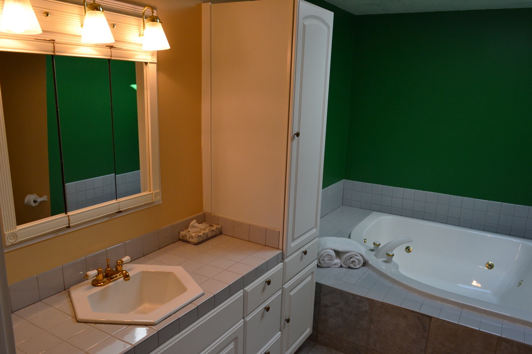 hotel restroom with bright green walls and large tub 