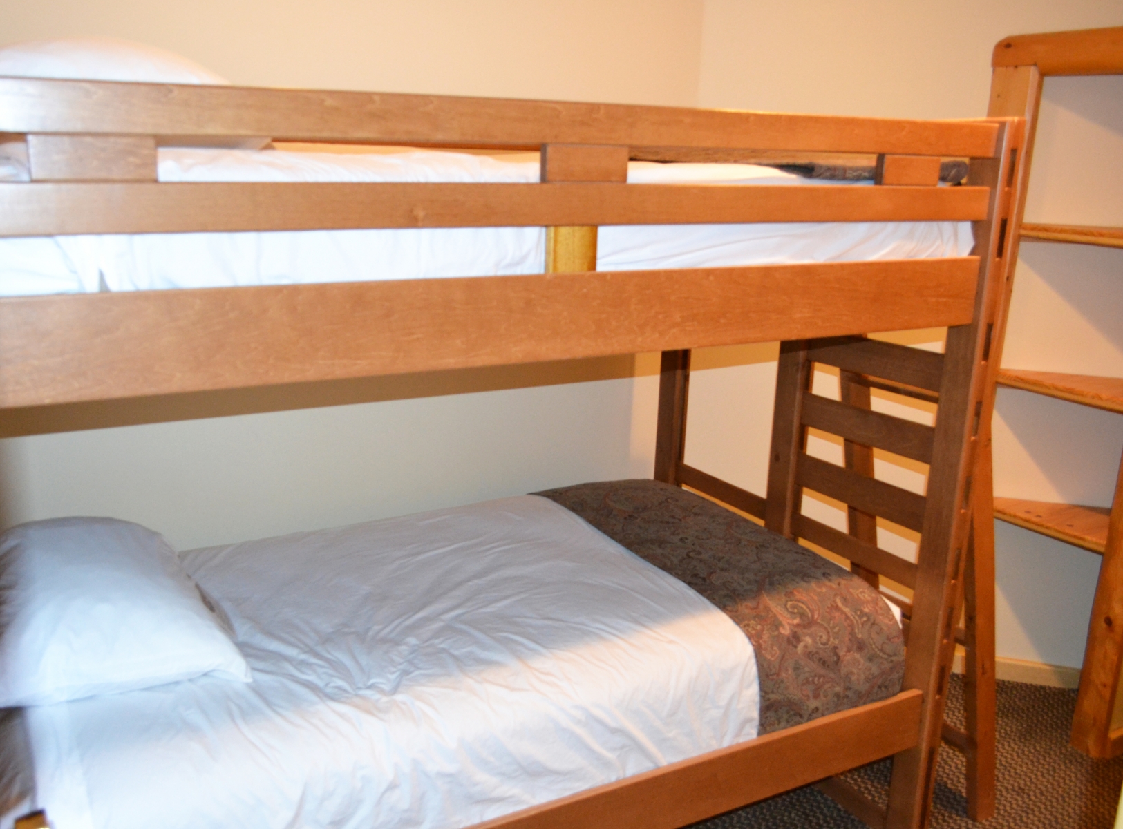 wooden bunkbeds with white sheets 