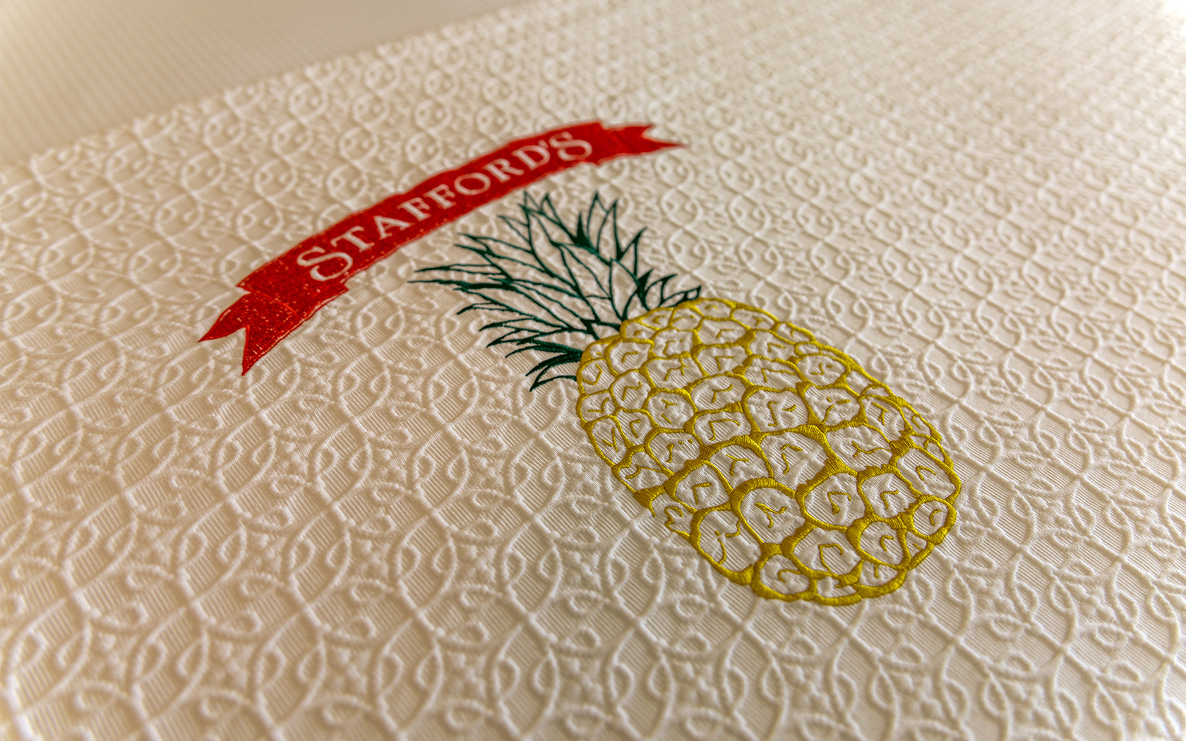 blanket with a pineapple and staffords logo 