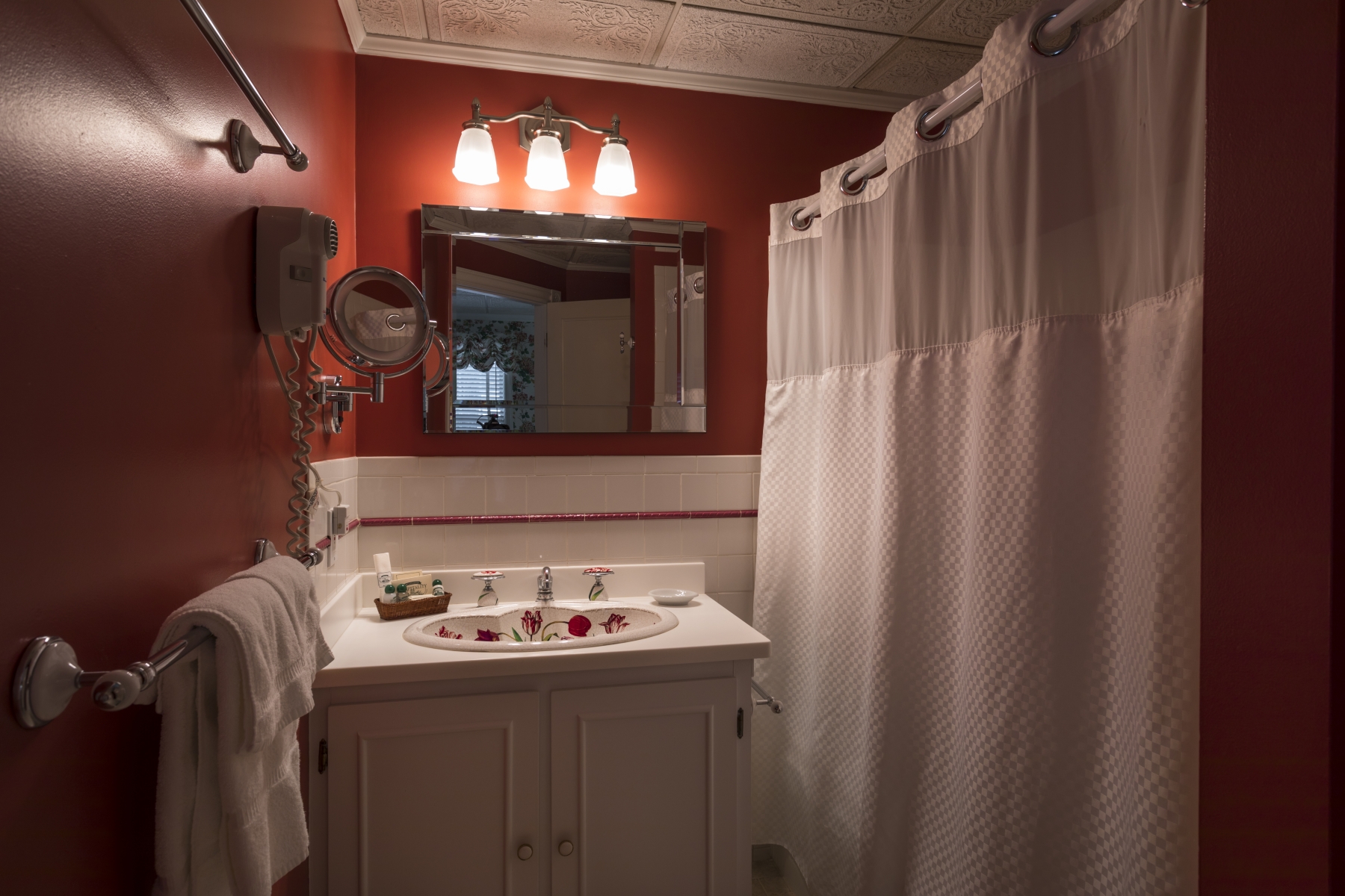 red bathroom with white shower curtain and white towels 