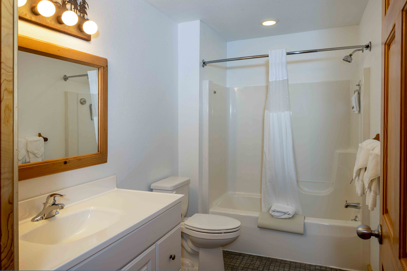 bathroom with a tub and white sink and a mirror