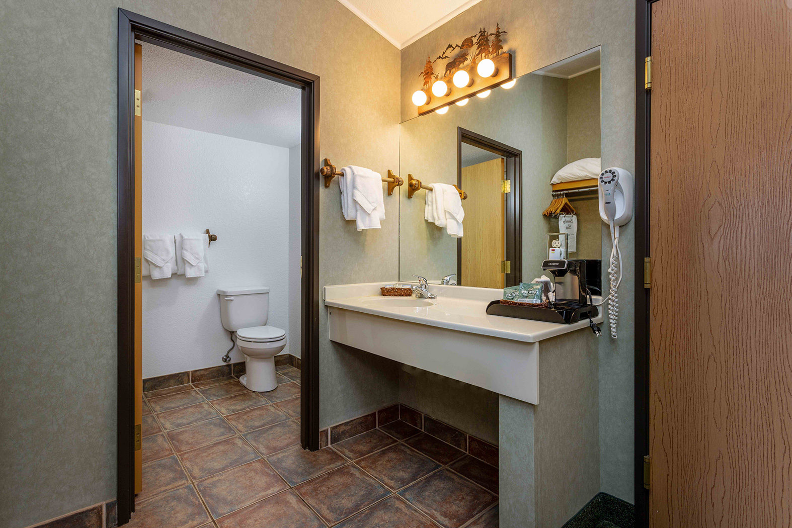 bathroom with a mirror and a white sink with towels
