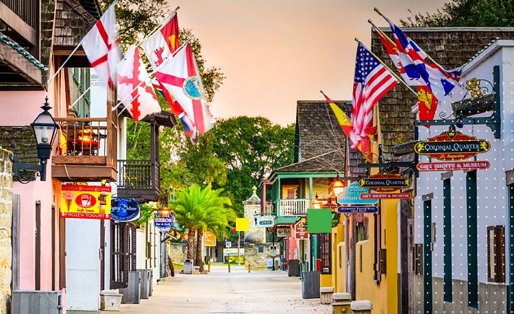 Street with colorful buildings and different flags hanging at their entrances