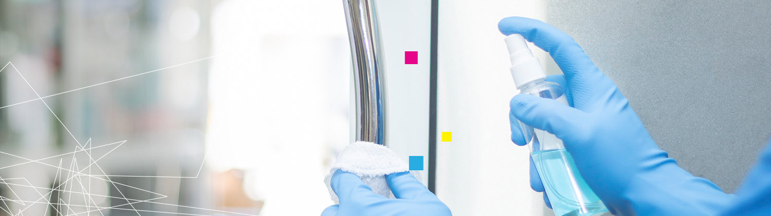 a worker spraying a surface with disinfectant