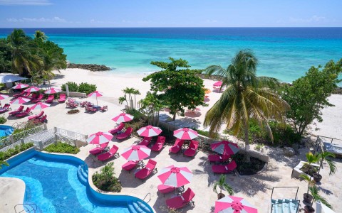 pool view and pink beach chairs and umbrella