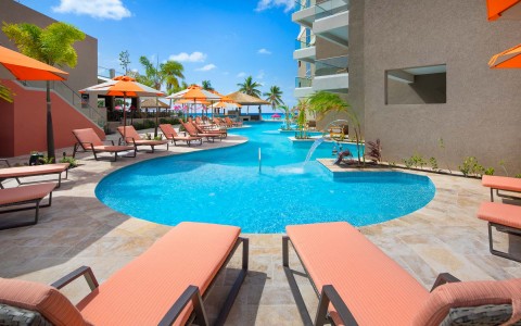 pool view with orange lounge chairs and umbrellas